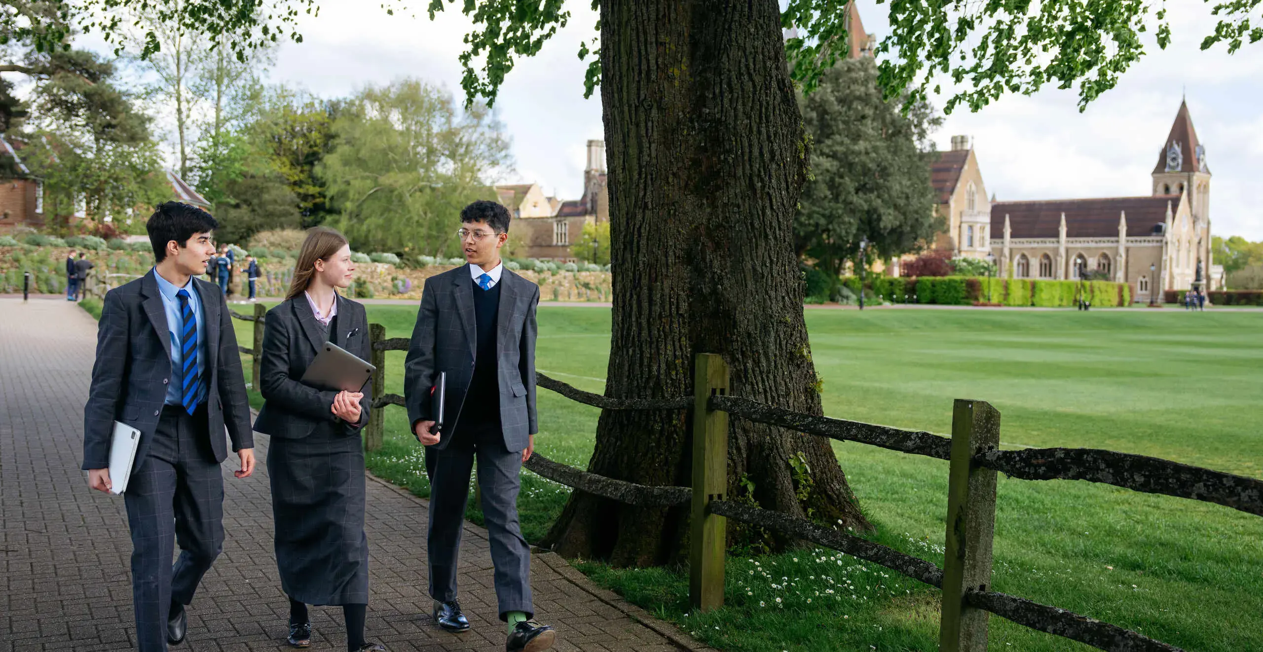 Three students walking along a path
