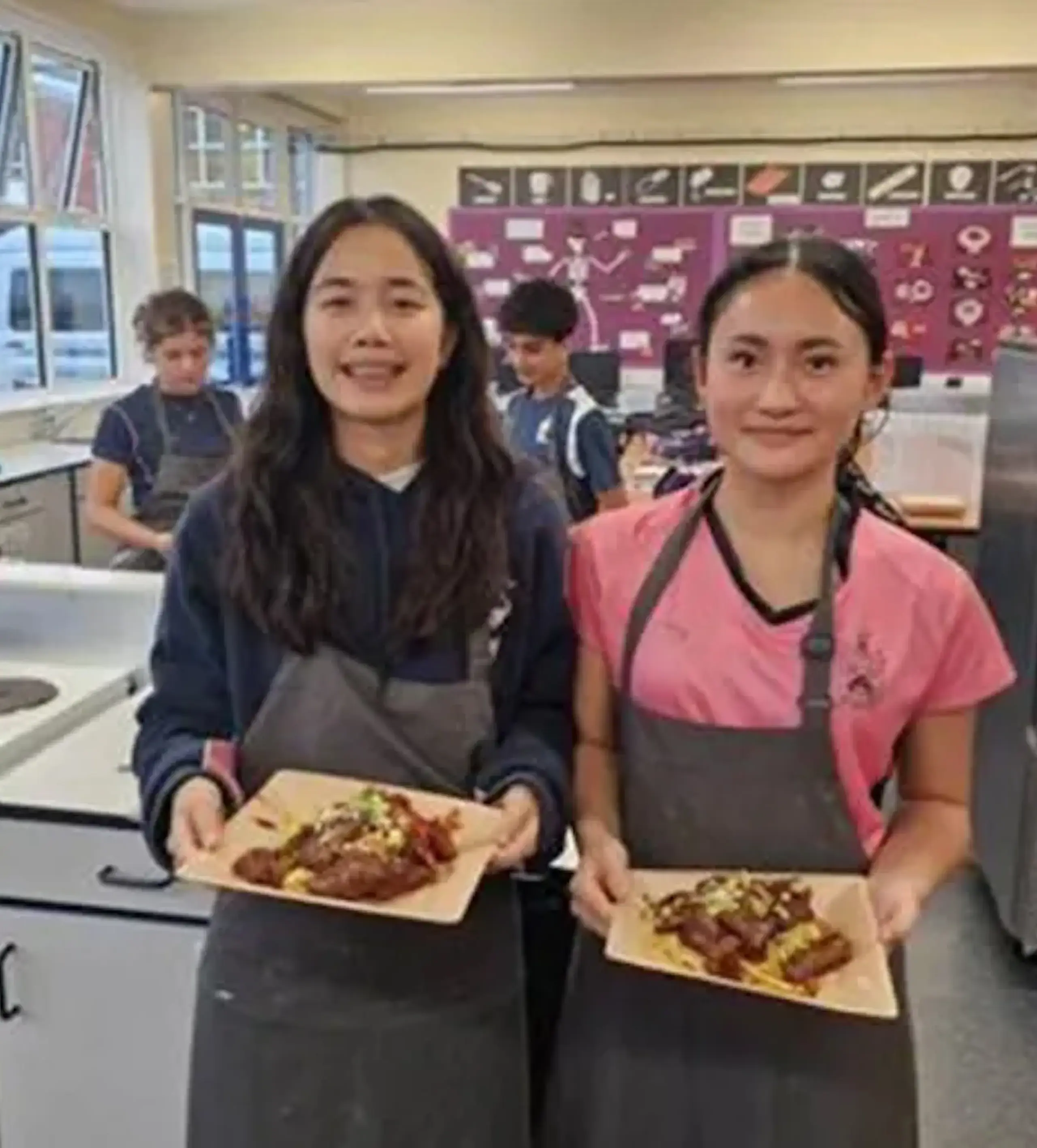 Students showing off their finished cooked dishes
