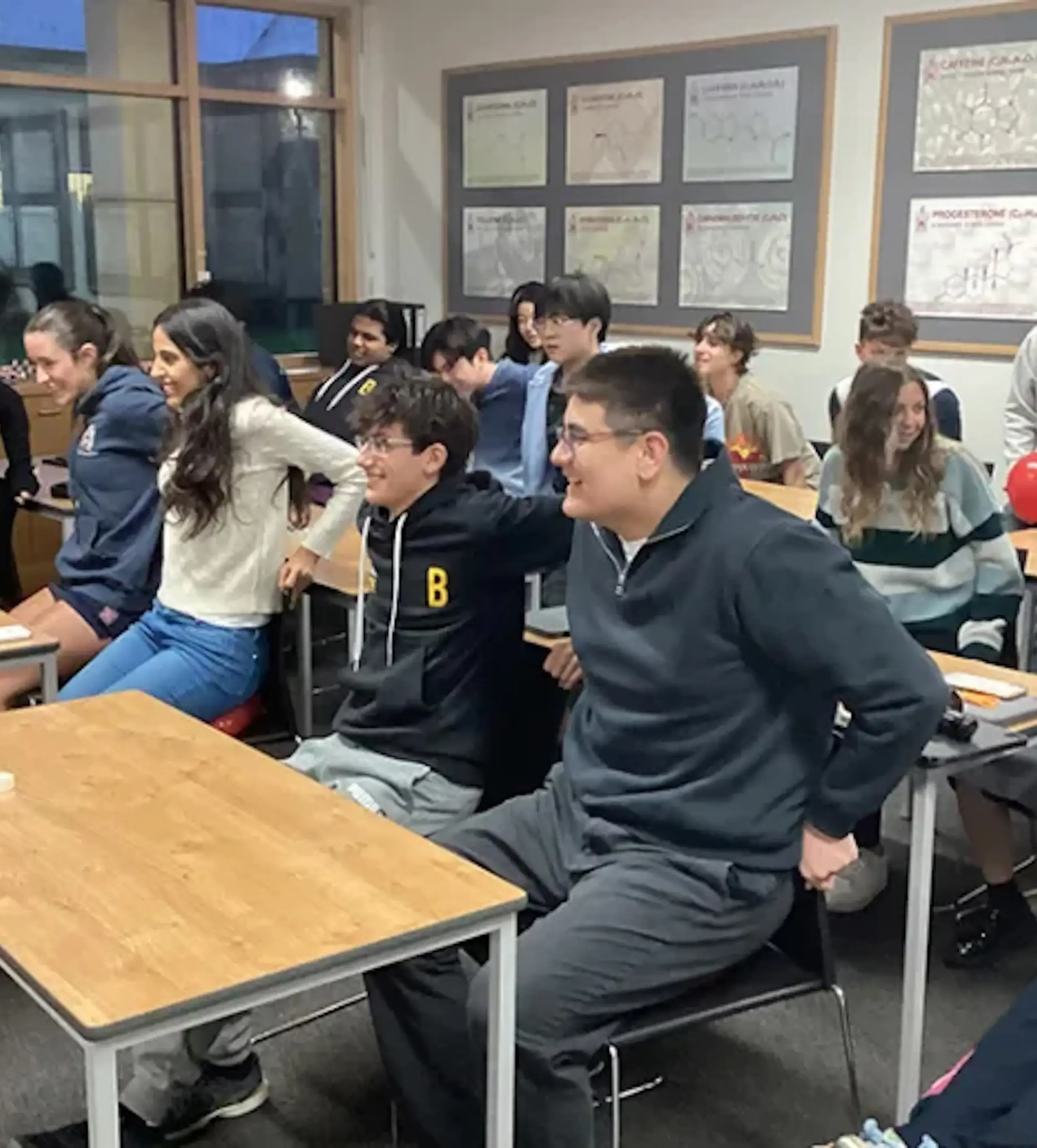 Studnets sitting at desks with their hands behind their back as part of an exercise