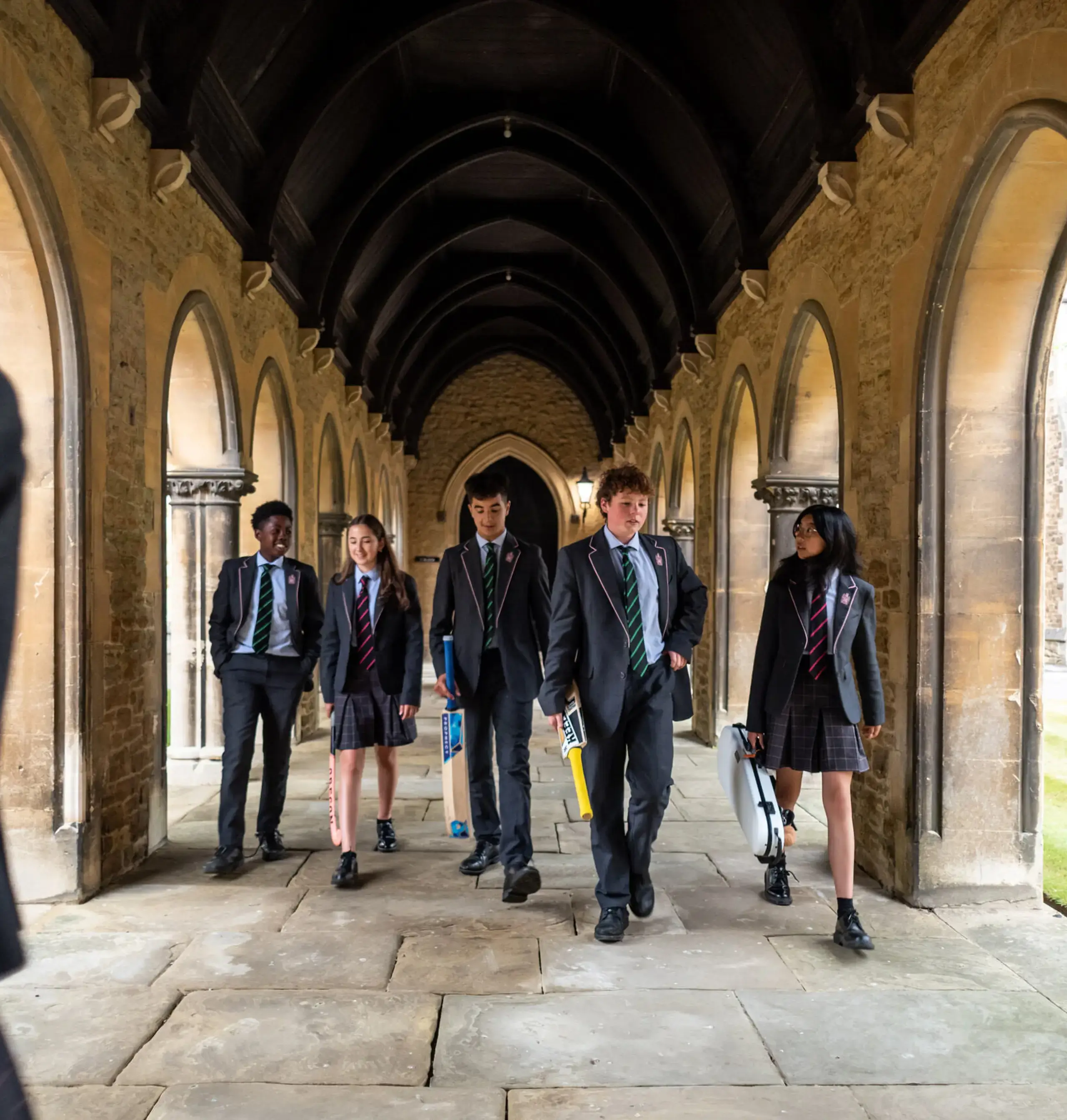 Students walking down a stone corridor